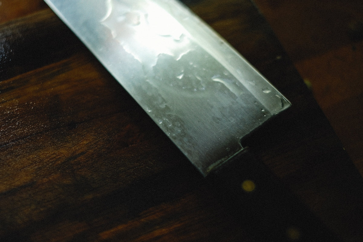 a large knife sitting on top of a wooden table